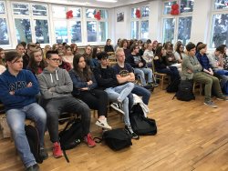 Zdjęcie kolorowe obrazujące salę wypełnioną siedzącą młodzieżą, która słucha nadkom. Elżbiety Żulewskiej podczas pogadanki profilaktycznej w szkole.