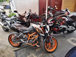 Fotografia w kolorze przedstawiająca stojące różnych marek motocykle. Na pierwszym planie 3 zabezpieczone pojazdy.