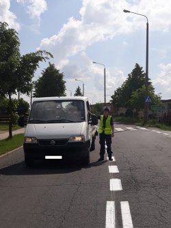 Fotografia kolorowa - policjantka ruchu drogowego zatrzymuje do kontroli drogowej busa.