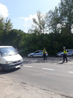 Fotografia kolorowa - patrol ruchu drogowego zatrzymał do kontroli drogowej kierowcę busa.