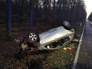 zdjęcie w kolorze - służby pracują na miejscu wypadku drogowego - dachowania peugeota